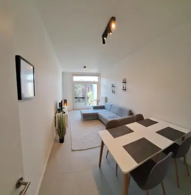 a living room with a table and a couch at Huis ALNA 3 in Mechelen
