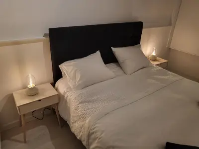 a bedroom with a large bed with two night stands at Huis ALNA 3 in Mechelen