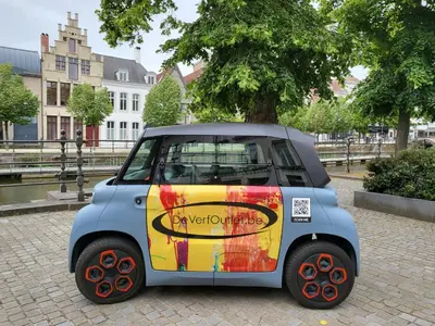 a small car is parked on a street at Huis ALNA 3 in Mechelen