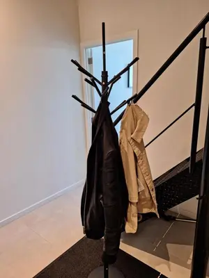 a pair of boots and a coat on the stairs at Huis ALNA 3 in Mechelen