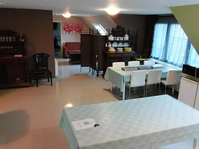 a living room with a table and chairs and a kitchen at loft/appartement golden dragon in Dessel