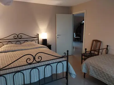 a bedroom with a bed and a table and a chair at loft/appartement golden dragon in Dessel
