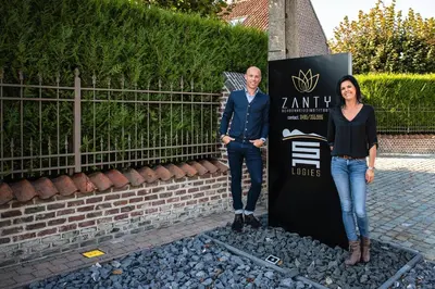 a man and a woman standing next to a sign at SN Logies in Tremelo