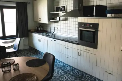 a kitchen with a table and a stove top oven at SN Logies in Tremelo