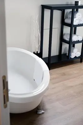 a white toilet in a bathroom with a shelf of towels at SN Logies in Tremelo