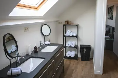 a bathroom with two sinks and a mirror at SN Logies in Tremelo