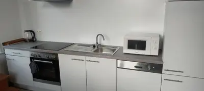 a kitchen with a sink and a microwave at De oude statie in Tessenderlo