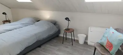 a bedroom with a bed and a lamp and a chair at De oude statie in Tessenderlo