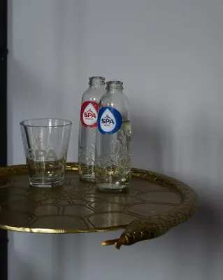 two bottles and a glass and a snake on a table at Hôtel La Pièce in Brussels