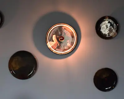 a light on a wall with four different types of objects at Hôtel La Pièce in Brussels