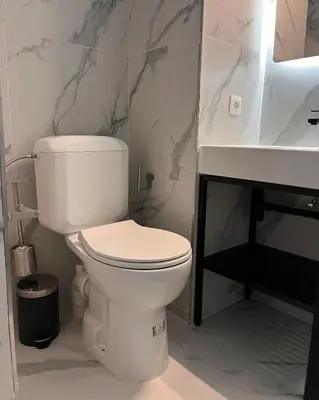 a bathroom with a white toilet and a sink at Hôtel La Pièce in Brussels