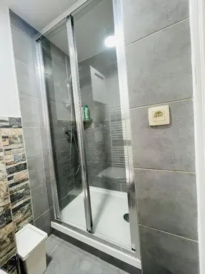 a shower with a glass door in a bathroom at Quiet and Colorfull Flat in the Center City of Brussels in Brussels