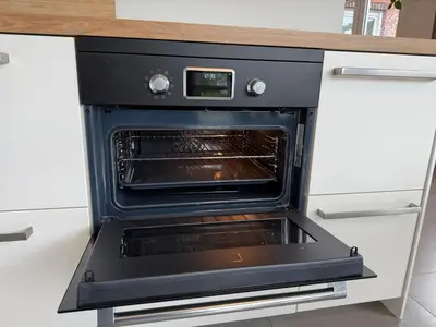an oven with its door open in a kitchen at Holiday Home De Steenen Molen in Brecht