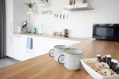 two coffee mugs sitting on a counter in a kitchen at Holiday Home De Steenen Molen in Brecht