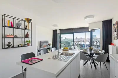 a kitchen with a sink and a table with chairs at Ernest 33 in Antwerp