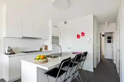 a kitchen with white cabinets and a bowl of fruit on a counter at Ernest 33 in Antwerp