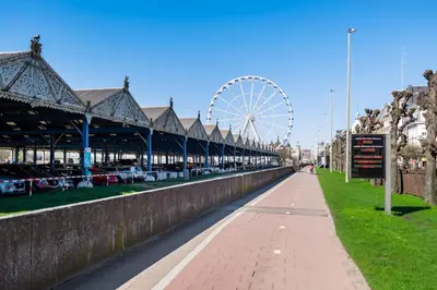 a large ferris wheel and a walkway next to a canal at Ernest 33 in Antwerp