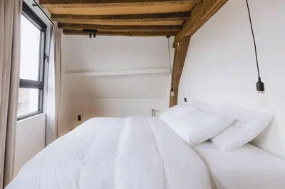 a bedroom with a white bed and a window at Kozy Home Spacious Luxurious home in Antwerp
