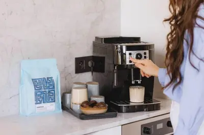 a woman pointing at a coffee maker on a counter at Kozy Home Spacious Luxurious home in Antwerp