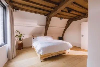 a bedroom with a white bed and a large window at Kozy Home Spacious Luxurious home in Antwerp
