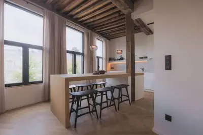 a kitchen with a bar with stools and some windows at Kozy Home Spacious Luxurious home in Antwerp