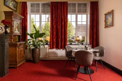 a dining room with a table and chairs and a window at Boutique hotel Sies in Watervliet