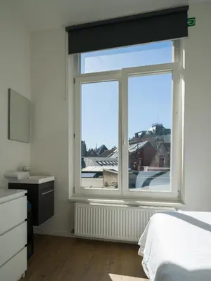 a bedroom with a bed and a window with a view at Julie's Boutique Guesthouse Ghent in Ghent