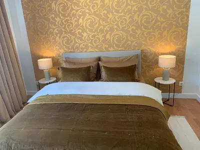 a bedroom with a large bed with two lamps at Coco’s place in Antwerp