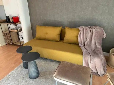 a living room with a bed with a blanket on it at Coco’s place in Antwerp