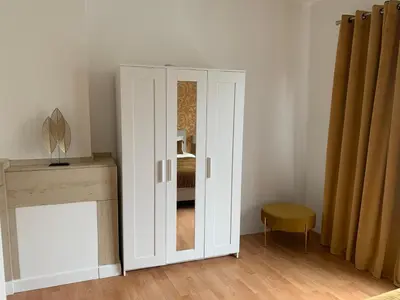 a white cabinet with a mirror in a room at Coco’s place in Antwerp