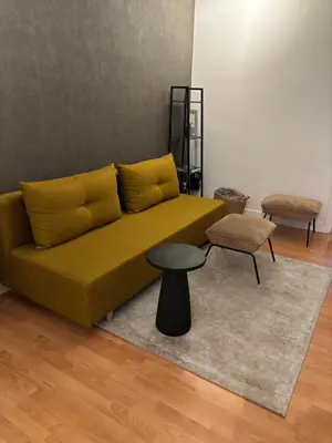 a living room with a yellow couch and a table at Coco’s place in Antwerp