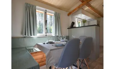 a dining room with a table and four chairs at Bungalow aan de Visbeekvallei in Vlimmeren