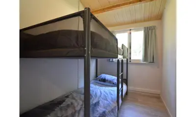 a bedroom with a bunk bed in a room at Bungalow aan de Visbeekvallei in Vlimmeren