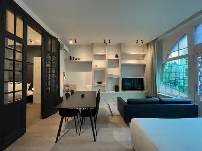 a room with a bed and a table and a couch at Historic 3 Bedroom Art-Nouveau Apartment with Airconditioning - Walk to Station Gent Sint-Pieters & Close to City Centre in Ghent
