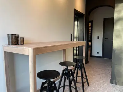 a kitchen with a wooden counter and stools at Historic 3 Bedroom Art-Nouveau Apartment with Airconditioning - Walk to Station Gent Sint-Pieters & Close to City Centre in Ghent