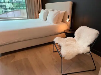 a bedroom with a bed and a chair and a window at Historic 3 Bedroom Art-Nouveau Apartment with Airconditioning - Walk to Station Gent Sint-Pieters & Close to City Centre in Ghent