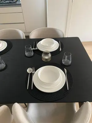 a black table with white plates and silverware on it at Cosy Apartment near Antwerp in Mortsel