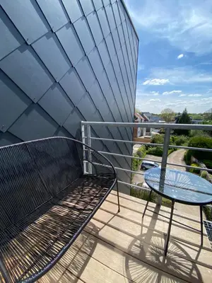 a metal bench on a balcony with a table at Cosy Apartment near Antwerp in Mortsel