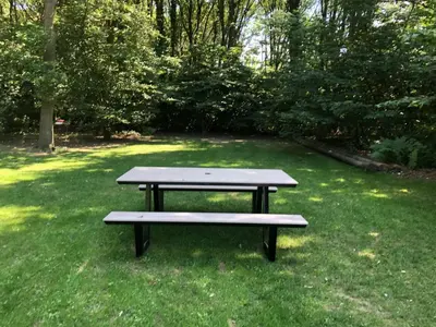 a picnic table sitting in the grass in a field at Vakantiewoningeikenhof in Londerzeel
