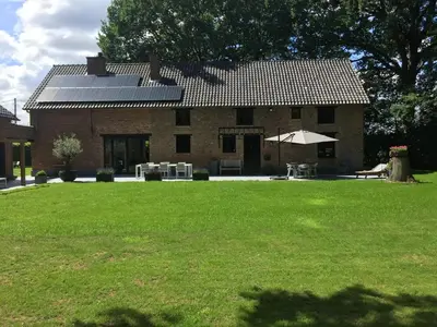 a brick house with a lawn in front of it at Vakantiewoningeikenhof in Londerzeel