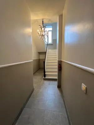 a hallway with a staircase and a chandelier at Design europarlament apartment with private terrace in Brussels