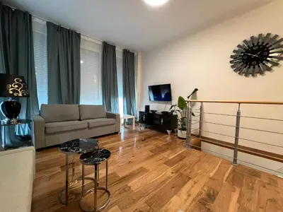 a living room with a couch and a table at Design europarlament apartment with private terrace in Brussels