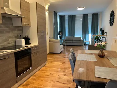 a kitchen and living room with a table and a dining room at Design europarlament apartment with private terrace in Brussels