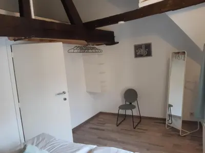 a bedroom with a bed and a chair in it at Het Maelslot (Mechelen) in Mechelen