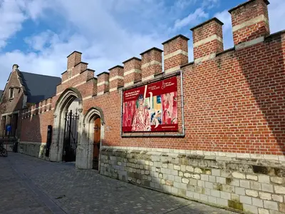 a brick building with a sign on the side of it at Het Maelslot (Mechelen) in Mechelen