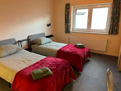 a room with two beds and a window at Les Cerisettes in Wavre