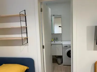 a bathroom with a sink and a washing machine at Les Cerisettes in Wavre