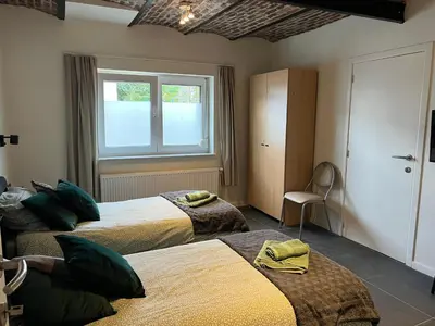 a hotel room with two beds and a window at Les Cerisettes in Wavre