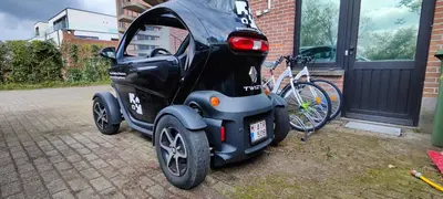 a small car is parked next to a bike at Fitness loft 50 m2 in Zemst