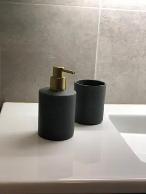 a bathroom with a black soap dispenser and a sink at De Kempische Akker in Westerlo
